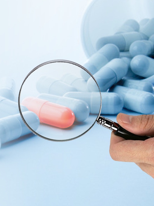 Magnifying glass highlighting one capsule among many